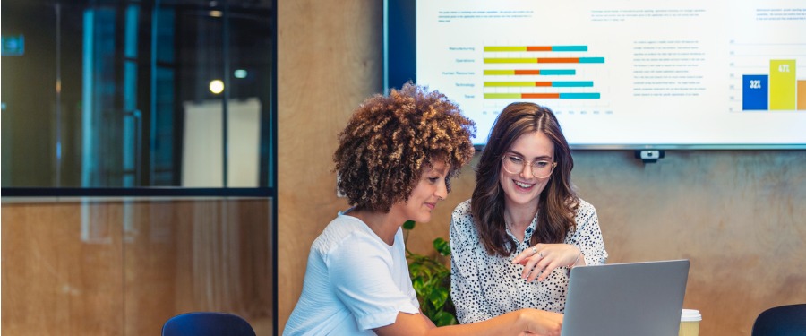 Two women discussing data from clinical trial recruitment tools