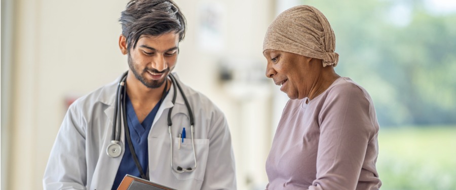 Male doctor discussing clinical trials with older female patient